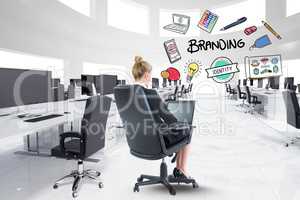 Digital composite image of businesswoman using laptop with branding text and icons in office