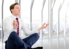 Business man meditating against blurry white window