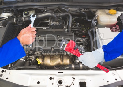Hands with tools repairing a car