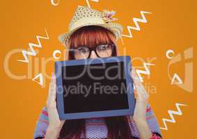 Woman in straw hat with tablet over face against orange background with white patterns