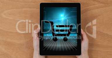Close-up of hands holding digital tablet with shopping cart icon on screen
