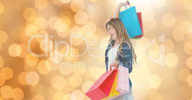 Cheerful woman with shopping bags over bokeh