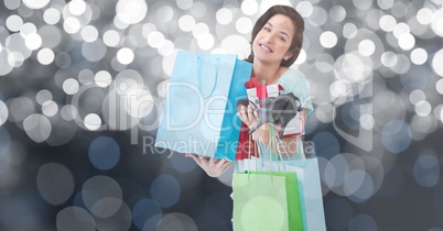 Portrait of woman carrying shopping bags and high heels against bokeh