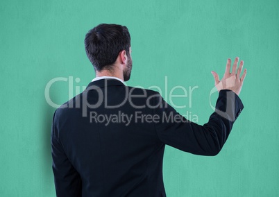 Rear view of businessman gesturing over green background