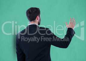 Rear view of businessman gesturing over green background