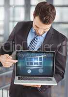 Man using Laptop with Shopping trolley icon