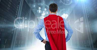 Back of business man superhero with hands on hips against servers with flares