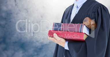 Judge holding book in front of sky clouds