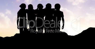 Silhouette children standing arms around each other against sky