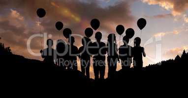 Silhouette children with balloons against sky