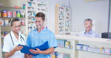 Doctors discussing at pharmacy store with worker in background
