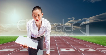 Digital composite image of businesswoman with laptop at starting point on racing track