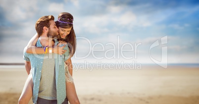 Young man kissing woman while piggybacking her at beach