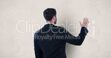 Rear view of businessman touching wall