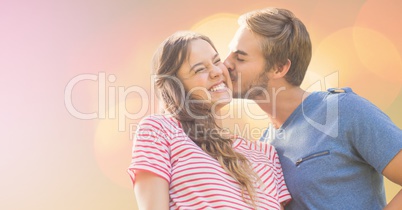 Loving man kissing happy woman on sunny day
