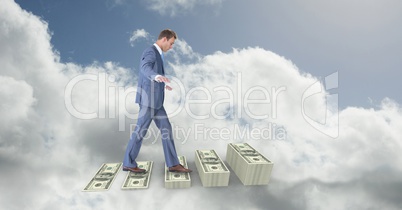 Digital composite image of businessman walking on money steps in sky