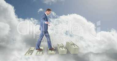 Digital composite image of businessman walking on money steps in sky