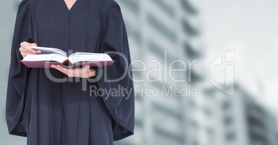 Judge holding book in front of buildings