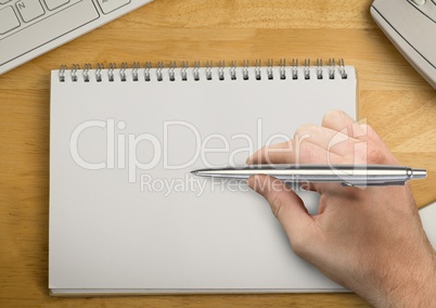 Hand with pen writing in notepad