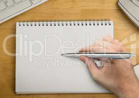 Hand with pen writing in notepad