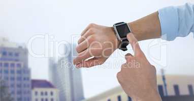 Hands with watch against blurry buildings