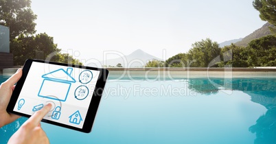 Hands using smart home app on tablet PC by pool
