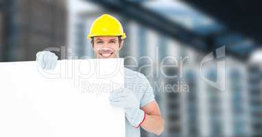 Portrait of smiling male architect holding blank billboard at construction site