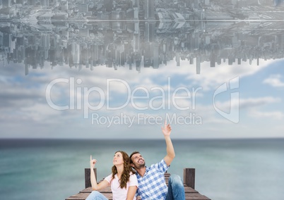 up side down city in the sky over the sea with couple sit on a dock and looking up