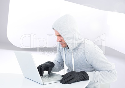 Criminal Man in hood on laptop in front of modern background