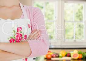 cook woman hand folded in the kitchen. Fruit a vegetables in the back