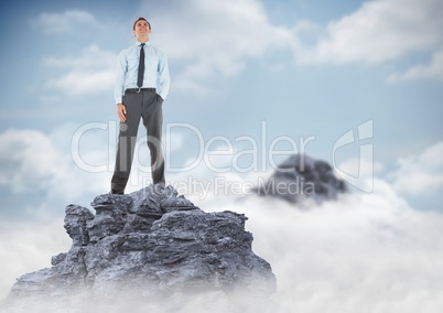 Business man hand in pocket on mountain peak in clouds