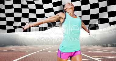 Female runner on track against flares and checkered flag