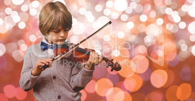 Little boy playing violin over bokeh