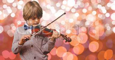 Little boy playing violin over bokeh