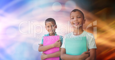 School children holding books against bokeh