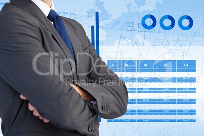 Midsection of businessman standing with graphs interface in background