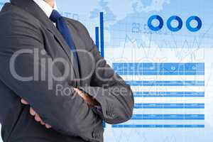 Midsection of businessman standing with graphs interface in background