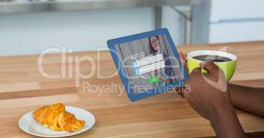 Cropped image of person holding digital tablet with join up page on screen while having coffee