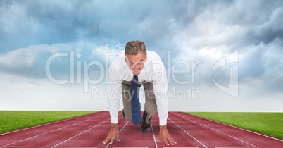 Businessman at starting position on tracks against storm clouds