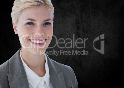 Business woman smiling against black wall