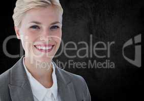 Business woman smiling against black wall