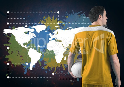 Football player holding ball next to Colorful Map with paint splatters on wall background