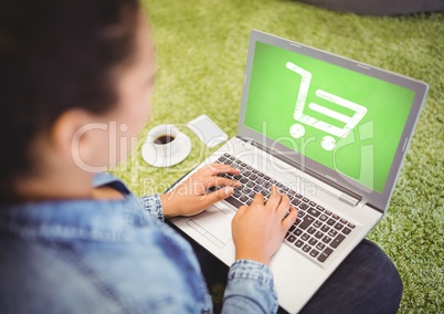 Woman using laptop with Shopping trolley icon