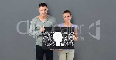 Portrait of couple holding billboard with various icons