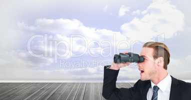 Digital composite image of surprised businessman using binoculars against cloudy sky