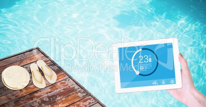 Woman using smart home app on tablet computer by swimming pool