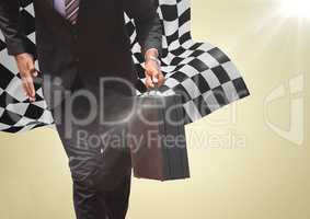 Business man lower body with briefcase against yellow background and checkered flag