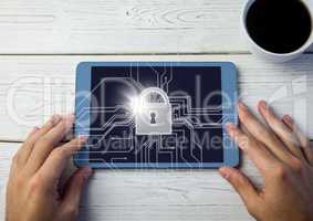 Overhead of hands with tablet and tea and white lock graphic with flare