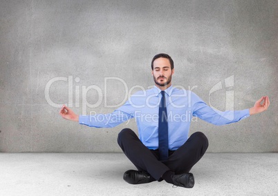 Business man meditating in grey room