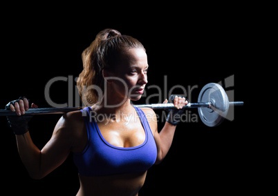 Female athlete with weights looking up against black background